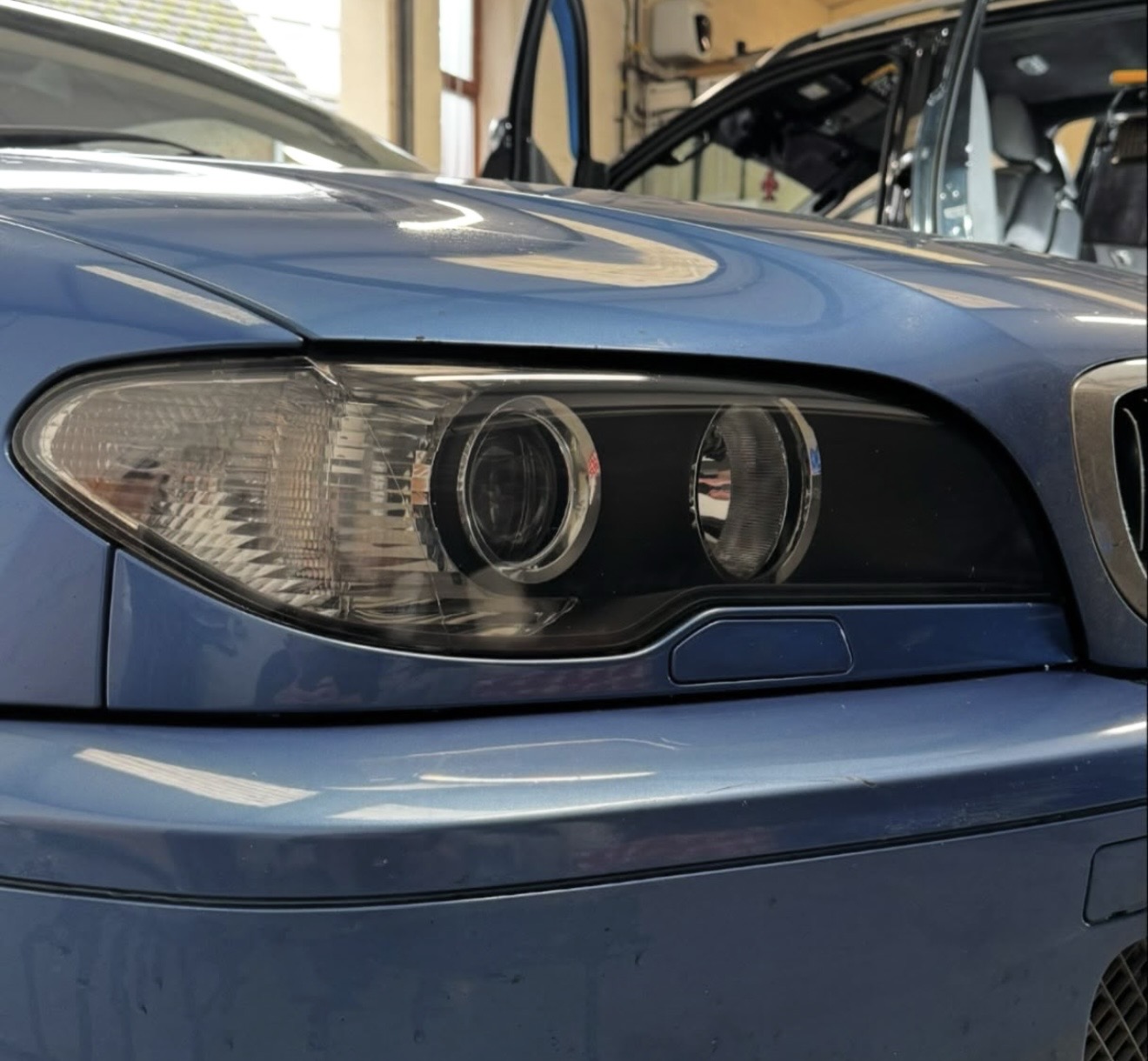 After restoration: the BMW headlight lens is clear, revealing the reflectors inside.