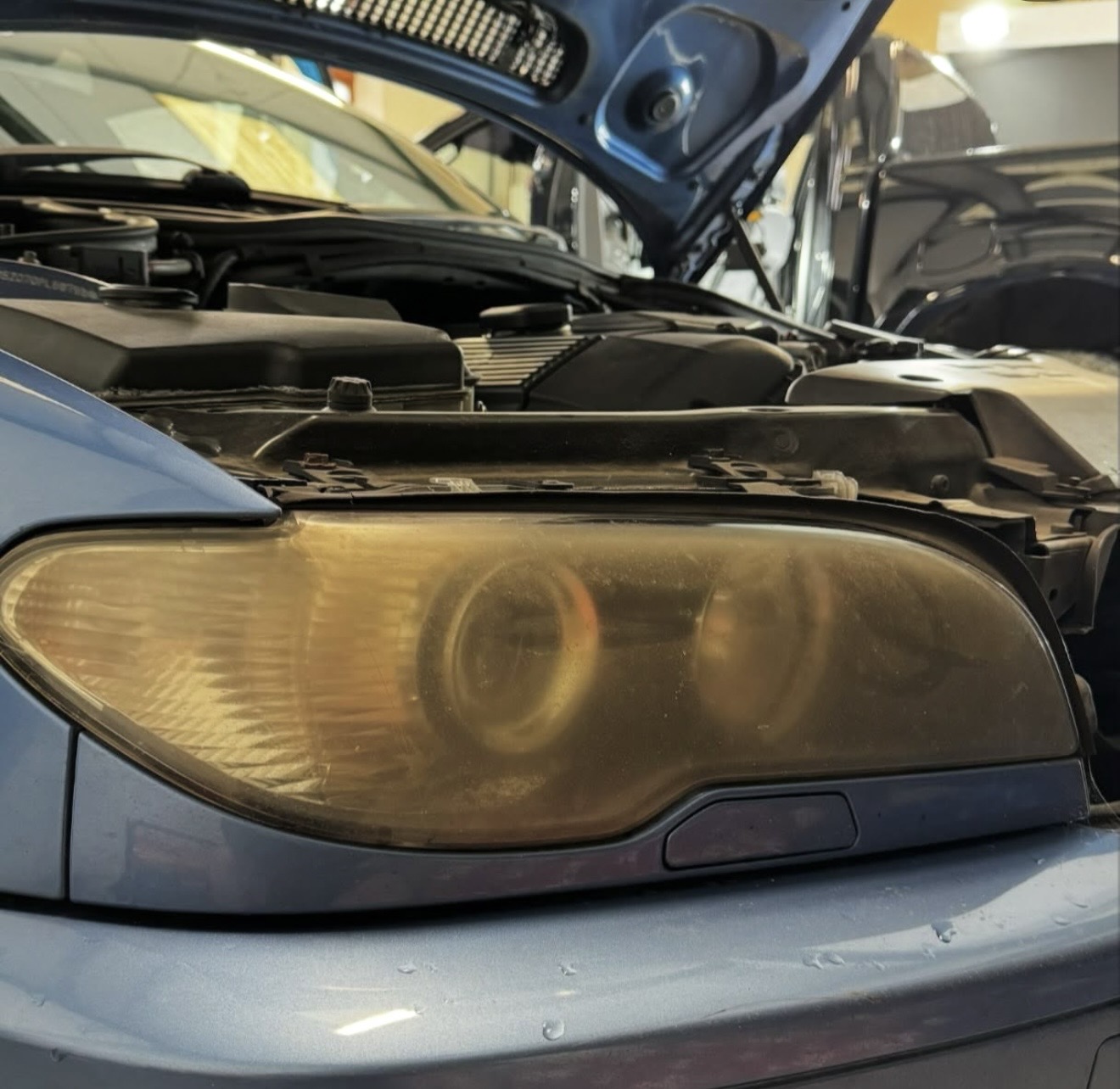 Before restoration: the BMW headlight lens is cloudy and yellowed.