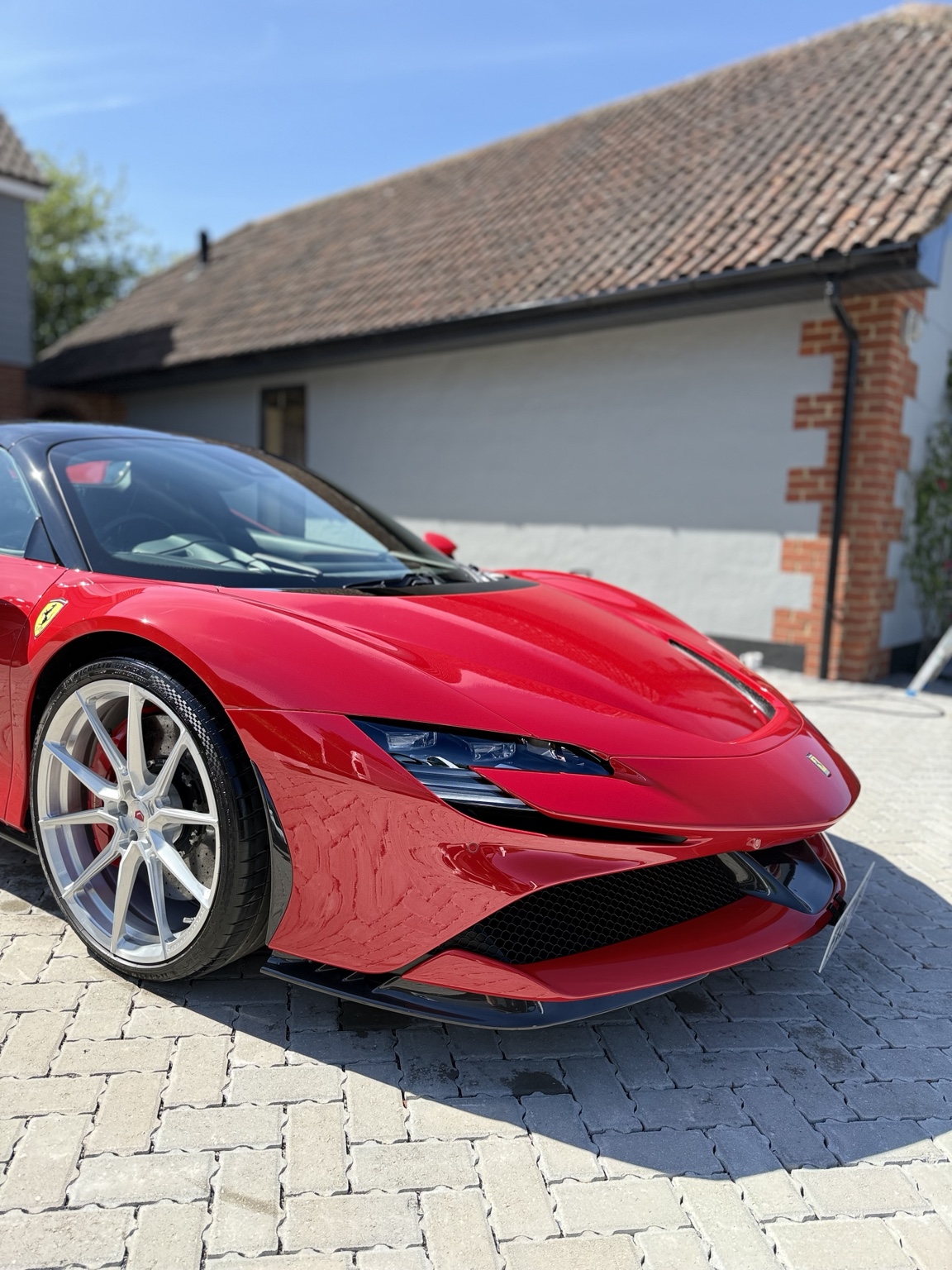 Front quarter of a red Ferrari in sunlight